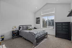 Carpeted bedroom featuring lofted ceiling