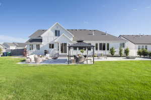 Back of property with a gazebo, an outdoor hangout area, and a patio