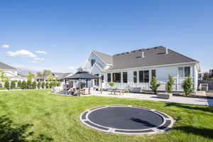 Back of property featuring a gazebo, a lawn, a patio, and a trampoline