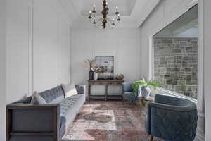 Sitting room featuring ornamental molding and a notable chandelier