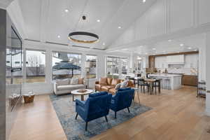 Living room featuring high vaulted ceiling, beam ceiling, a wealth of natural light, and light hardwood / wood-style flooring