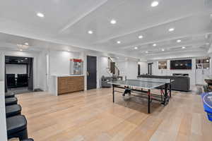 Recreation room featuring beam ceiling, light hardwood / wood-style floors, and built in features