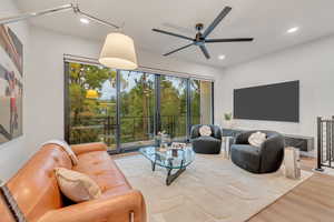 Living room with ceiling fan and light hardwood / wood-style floors