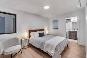 Bedroom featuring ensuite bathroom, sink, and light hardwood / wood-style floors