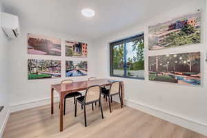 Dining area featuring hardwood / wood-style floors and a wall unit AC