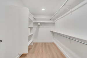 Spacious closet with light hardwood / wood-style floors