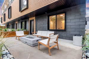 Patio terrace at dusk featuring an outdoor fire pit