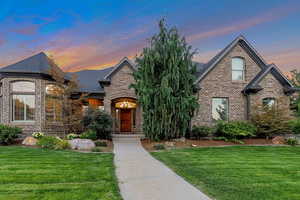 French country inspired facade with a yard