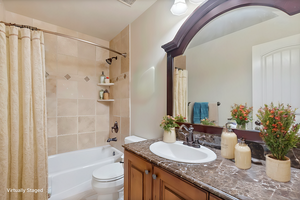 Virtually staged - Full bathroom featuring vanity, toilet, and shower / bath combo