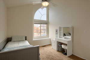 Bedroom featuring light carpet, vaulted ceiling, and ceiling fan