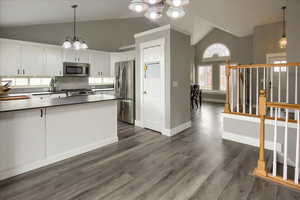 Kitchen featuring decorative light fixtures, an inviting chandelier, stainless steel appliances, and white cabinetry