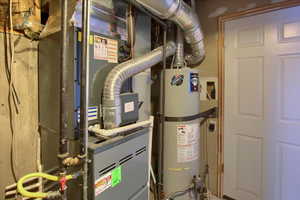 Utility room featuring gas water heater and heating unit