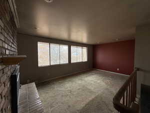 Unfurnished living room featuring a fireplace and carpet floors