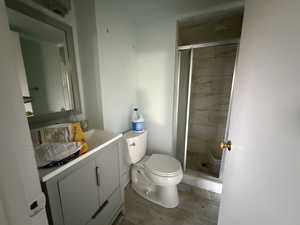 Bathroom with vanity, toilet, and an enclosed shower