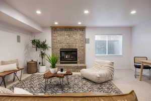 Living room with carpet flooring and a brick fireplace