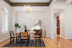 Dining area featuring light hardwood / wood-style floors and an inviting chandelier