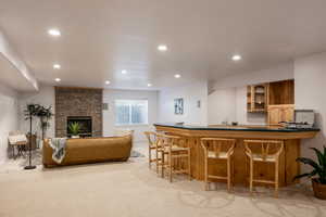 Bar featuring light colored carpet and a brick fireplace