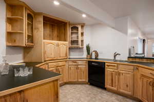 Kitchen with beam ceiling, sink, and black dishwasher