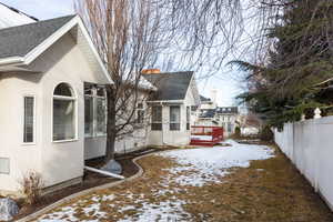 View of snow covered exterior with a wooden deck