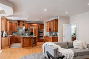 Kitchen featuring a center island, a kitchen bar, backsplash, and appliances with stainless steel finishes