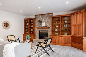 Living room featuring light colored carpet and a brick fireplace