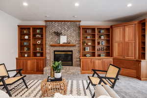 Carpeted living room featuring a brick fireplace