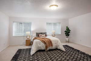 Bedroom featuring light colored carpet and a textured ceiling