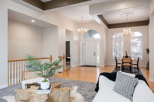 Carpeted foyer with a chandelier