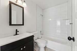 Full bathroom featuring updated vanity, toilet, new tile in shower.