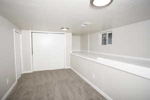 Basement with carpet and a textured ceiling