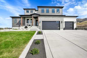 View of front of property with a garage and a front lawn