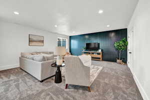 Carpeted living room with wood walls