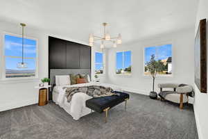 Bedroom featuring dark colored carpet, multiple windows, and a notable chandelier