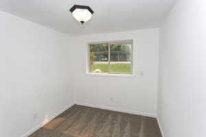 Empty room featuring dark colored carpet