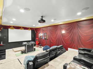 Home theater featuring crown molding and carpet