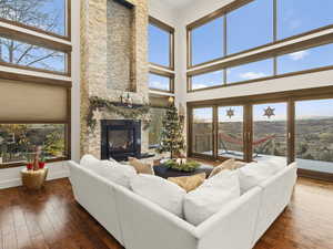 Living room with a wealth of natural light, a fireplace, and a high ceiling