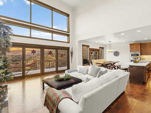 Living room with dark hardwood / wood-style floors, ornamental molding, and a wealth of natural light