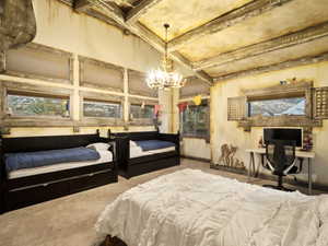 Bedroom featuring carpet flooring, beam ceiling, and a chandelier