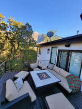 Deck with a mountain view and an outdoor living space with a fire pit