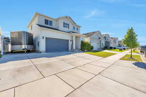 View of front of home featuring a garage and a front lawn and RV parking.