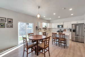 Dining space with light hardwood / wood-style flooring