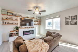 Living room with light hardwood / wood-style flooring and ceiling fan