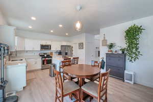 Dining room and kitchen with light hardwood / wood-style flooring