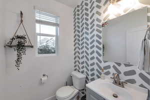 Bathroom featuring backsplash, vanity, and toilet