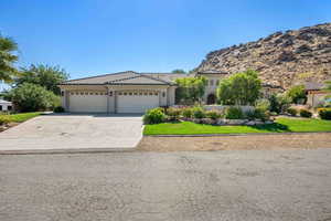 Mediterranean / spanish home featuring a mountain view, a front yard, and a garage