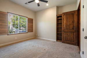 Carpeted spare room featuring ceiling fan