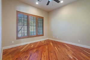 Spare room with hardwood / wood-style flooring and ceiling fan