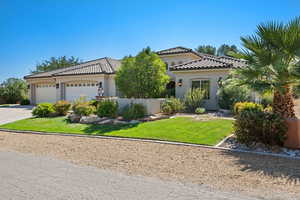 Mediterranean / spanish house with a front yard and a garage