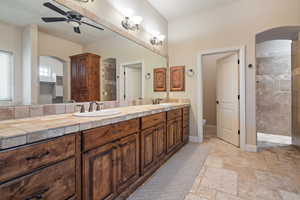 Bathroom with vanity, ceiling fan, toilet, and a shower