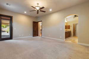 Unfurnished room featuring light colored carpet and ceiling fan